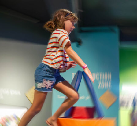 A child leaps through the air while playing in the Kid-Struction Zone at MOHAI.