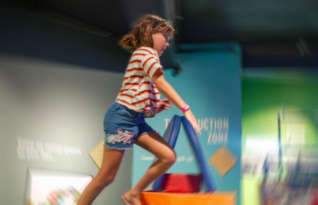 A child leaps through the air while playing in the Kid-Struction Zone at MOHAI.