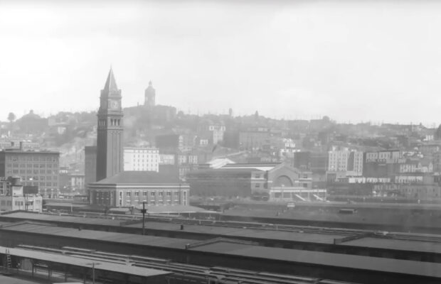 Historic black and white photo of exterior of King Street Station located in Seattle's Pioneer Square district.