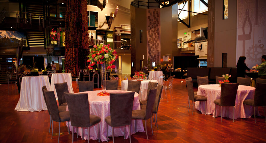 The Faye G. Allen Grand Atrium set up with table rounds and red flowers as center pieces.