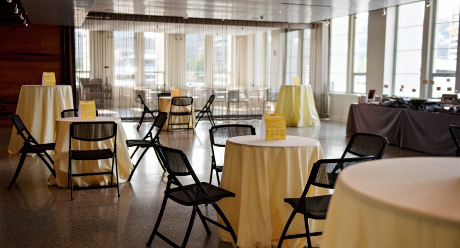 The Microsoft Lakefront Pavilion at MOHAI with small round tables covered in cream colored table cloths.