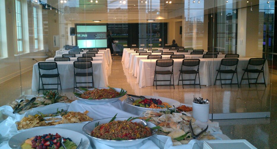 The Microsoft Lakefront Pavilion at MOHAI shown with tables covered in white table cloths and a buffet of food.