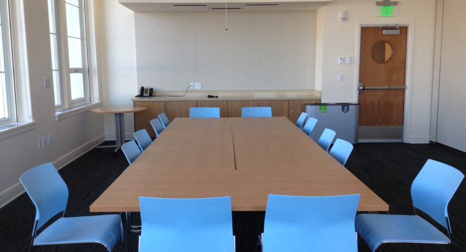 The Norcliffe conference room west shows movie screen (closed), tables, and blue chairs.