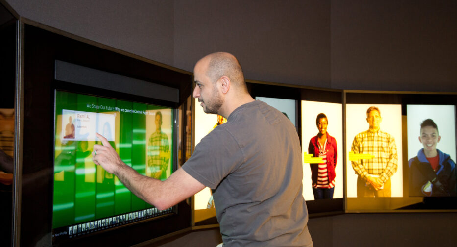Visitor engaging with touch screen within the Bezos Center for Innovation Exhibit at MOHAI.