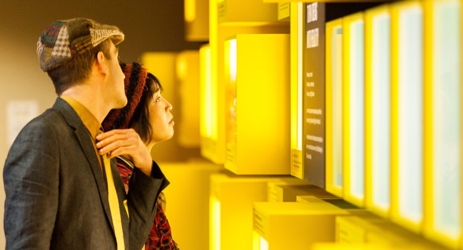 A couple in the Bezos Center for Innovation exhibit reading signs on the wall.