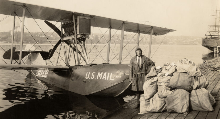 Eddie Hubbard stands at the nose of the Boeing B1 US mail plane on the shores of Lake Union in 1919.
