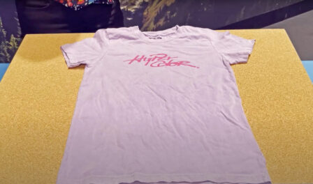 A pink Hyper Color t-shirt lies on a table.