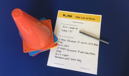 Programming logic steps on a piece of paper adjacent to a stack of colored cones.