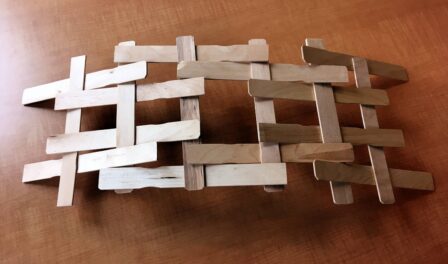 Arching bridge built with tongue depressors made in the style of DaVinci.