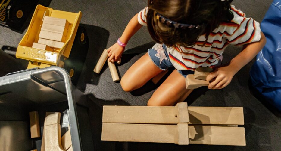A child plays with wooden blocks in the Kid-Struction Zone at MOHAI.