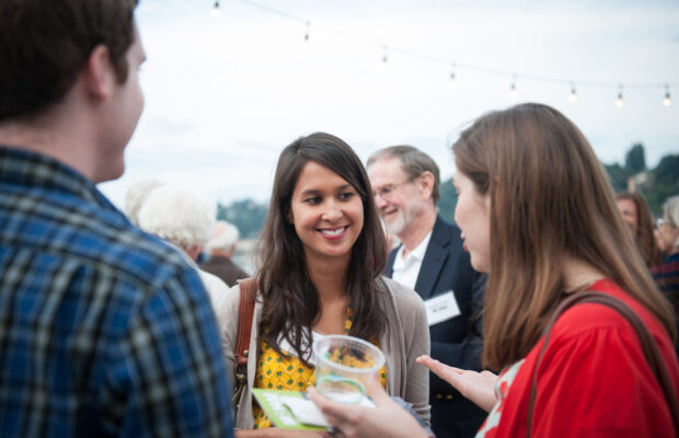 Attendees milling about on the terrace at MOHAI enjoying drinks and conversing.