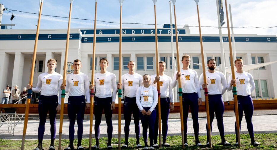 The University of Washington Men's Crew Team standing outside MOHAI holding oars.