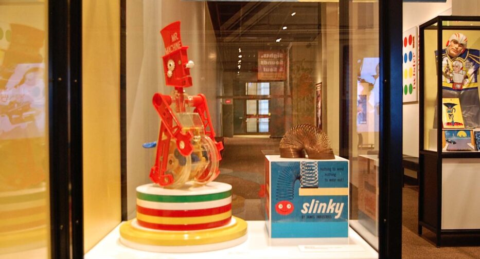 Toys from the 1950s including an original Slinky displayed adjacent to a Mr. Machine.