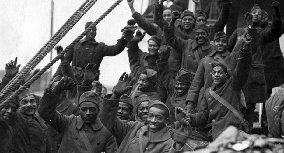 WW1 soldiers of color wave to the camera.