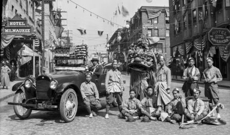 Chinese dance group with decorated car on King Street in downtown Seattle, WA, circa 1921.