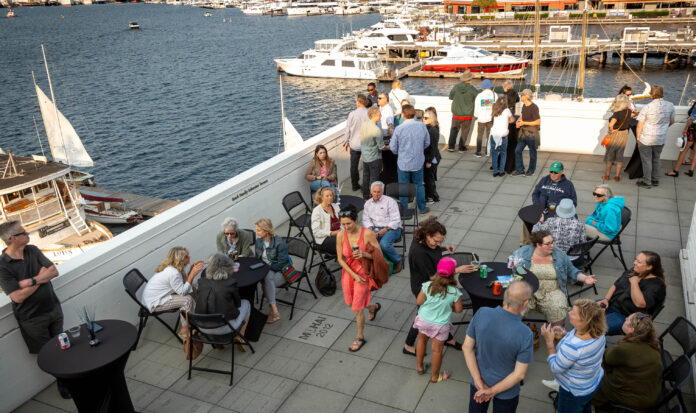 Summer Nights on the Terrace attendees in the foreground. Lake Union and docked boats in the background.