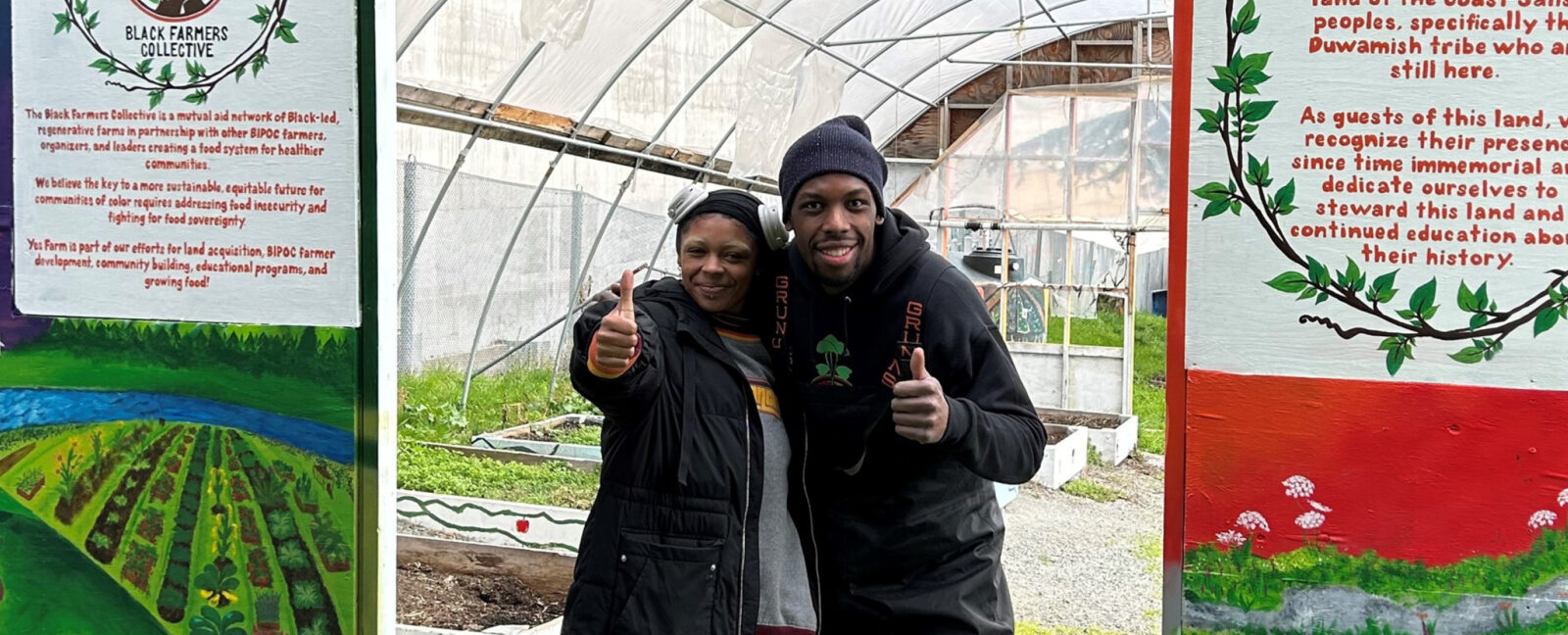 Members of the Black Farmers Collective pose before a green house in Seattle.