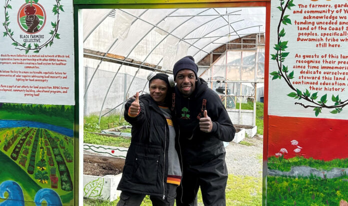 Members of the Black Farmers Collective pose before a green house in Seattle.