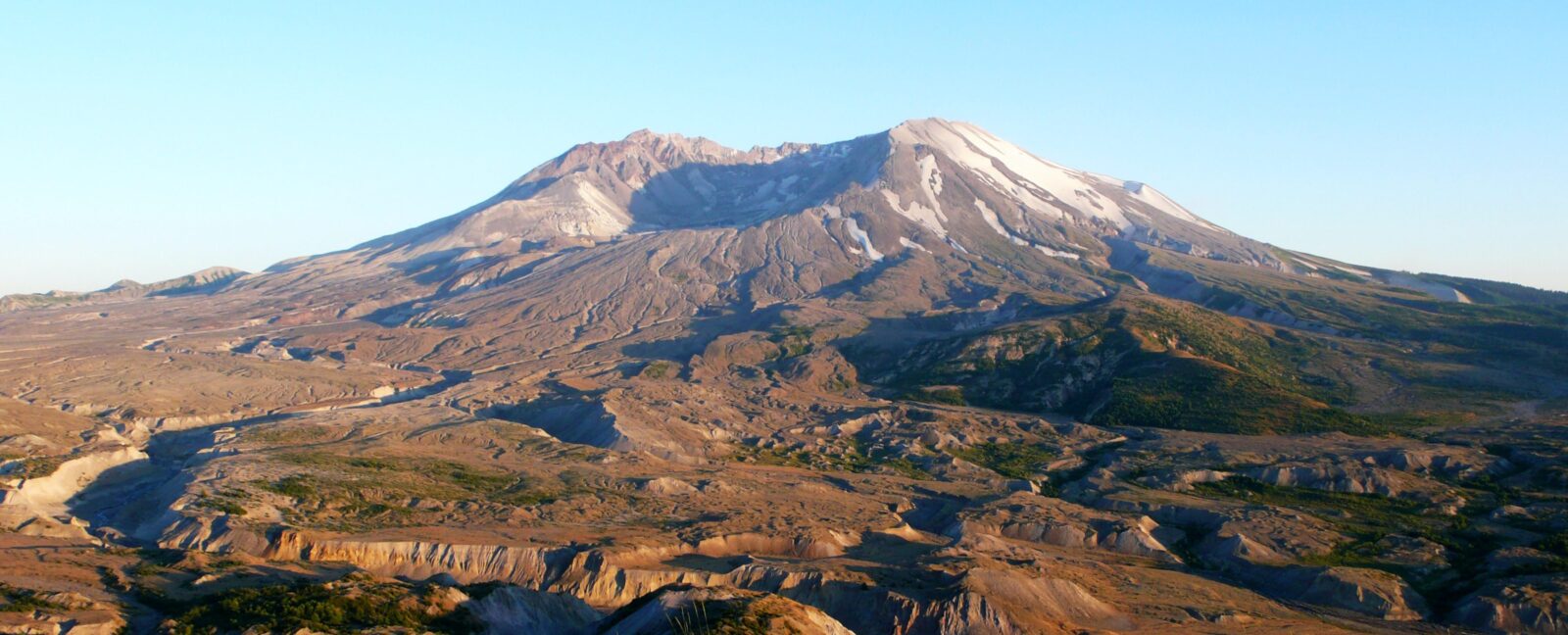 View of mountain with scooped out peak set against clear blue sky.