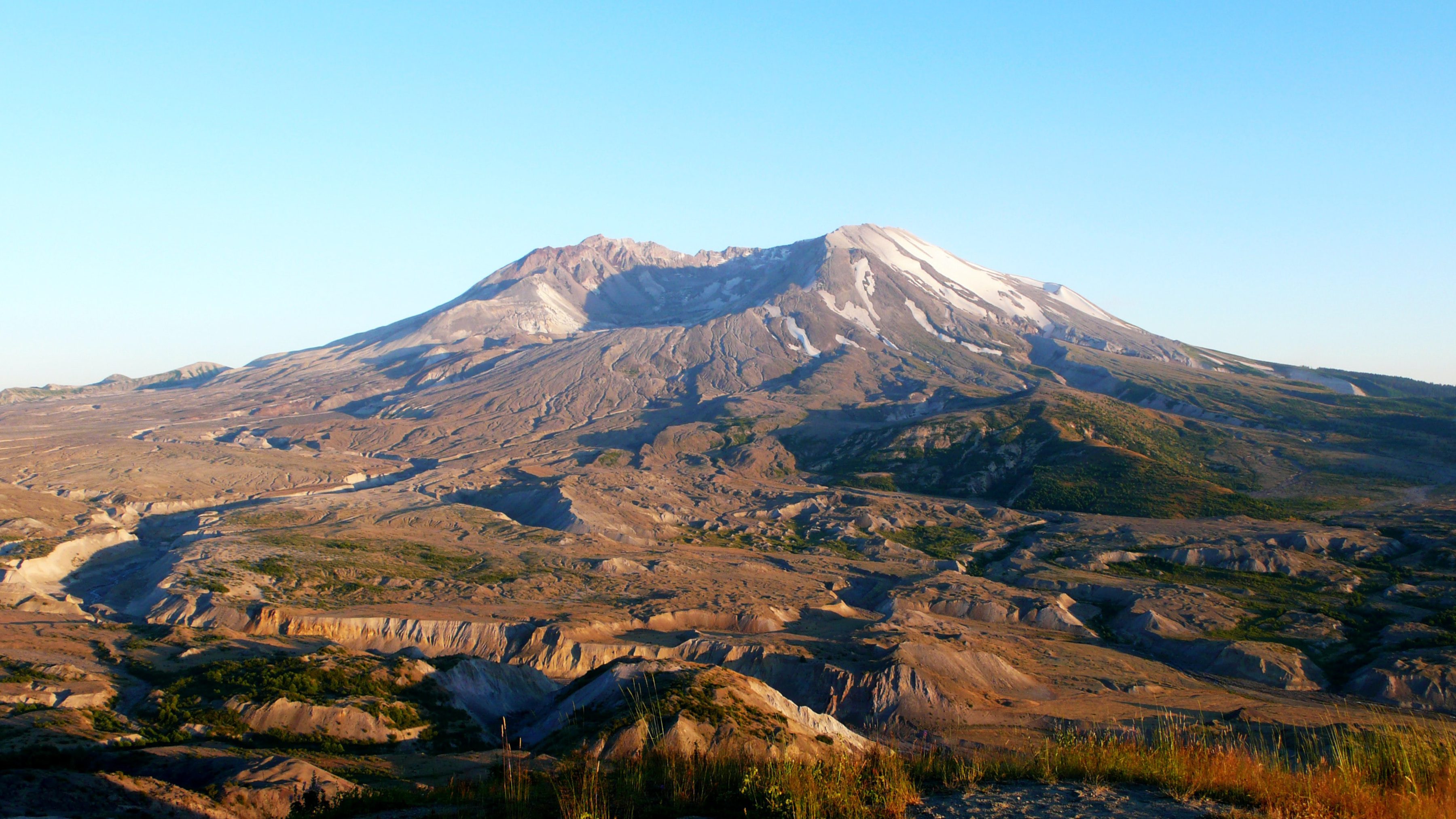 View of mountain with scooped out peak set against clear blue sky.