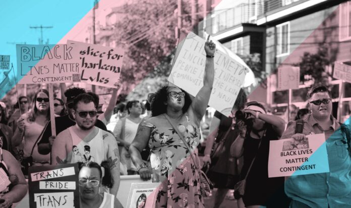 Group of people marching with Black Lives Matter and Trans Pride signs.