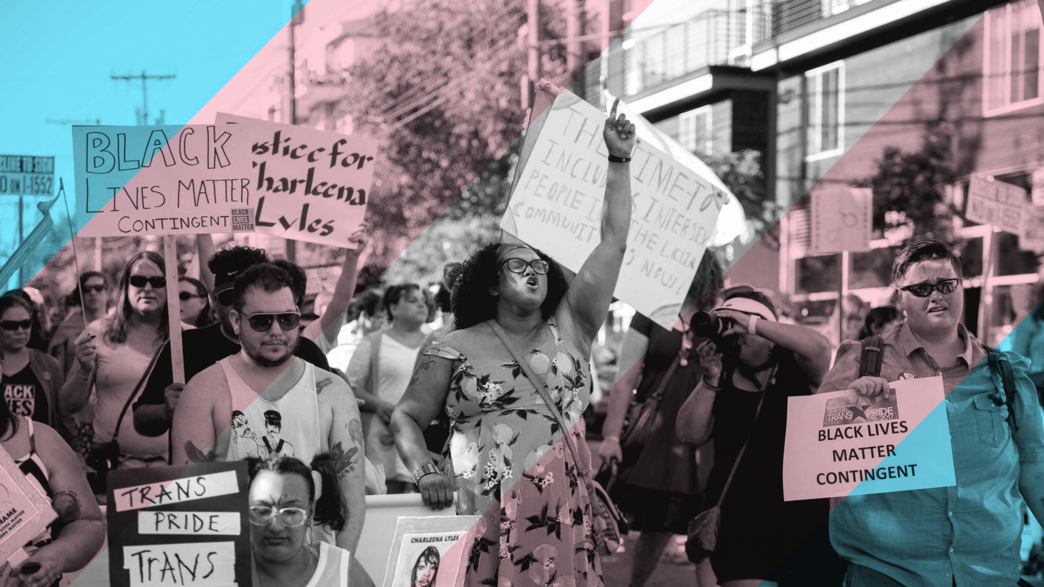 Group of people marching with Black Lives Matter and Trans Pride signs.