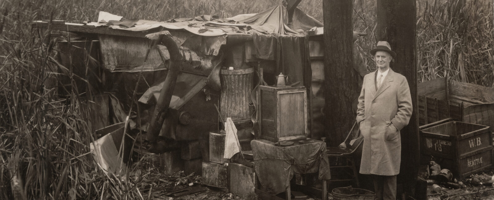 Mayor Robert Harlan standing by a shack at Hooverville
