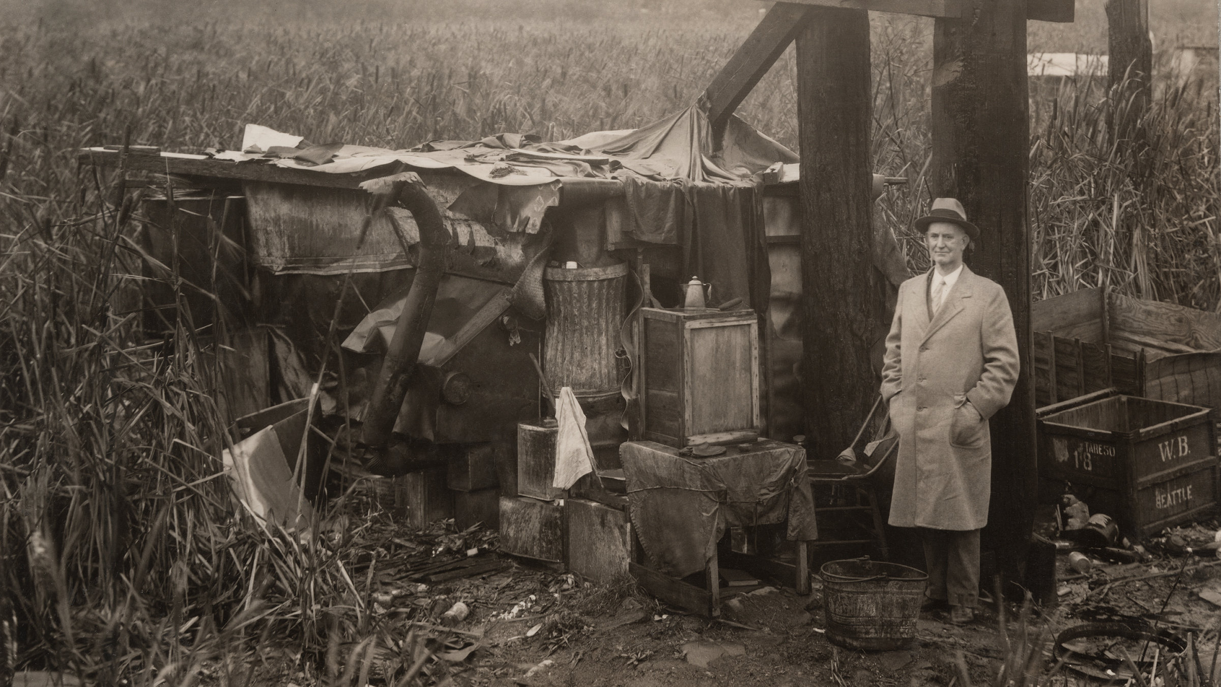 Mayor Robert Harlan standing by a shack at Hooverville