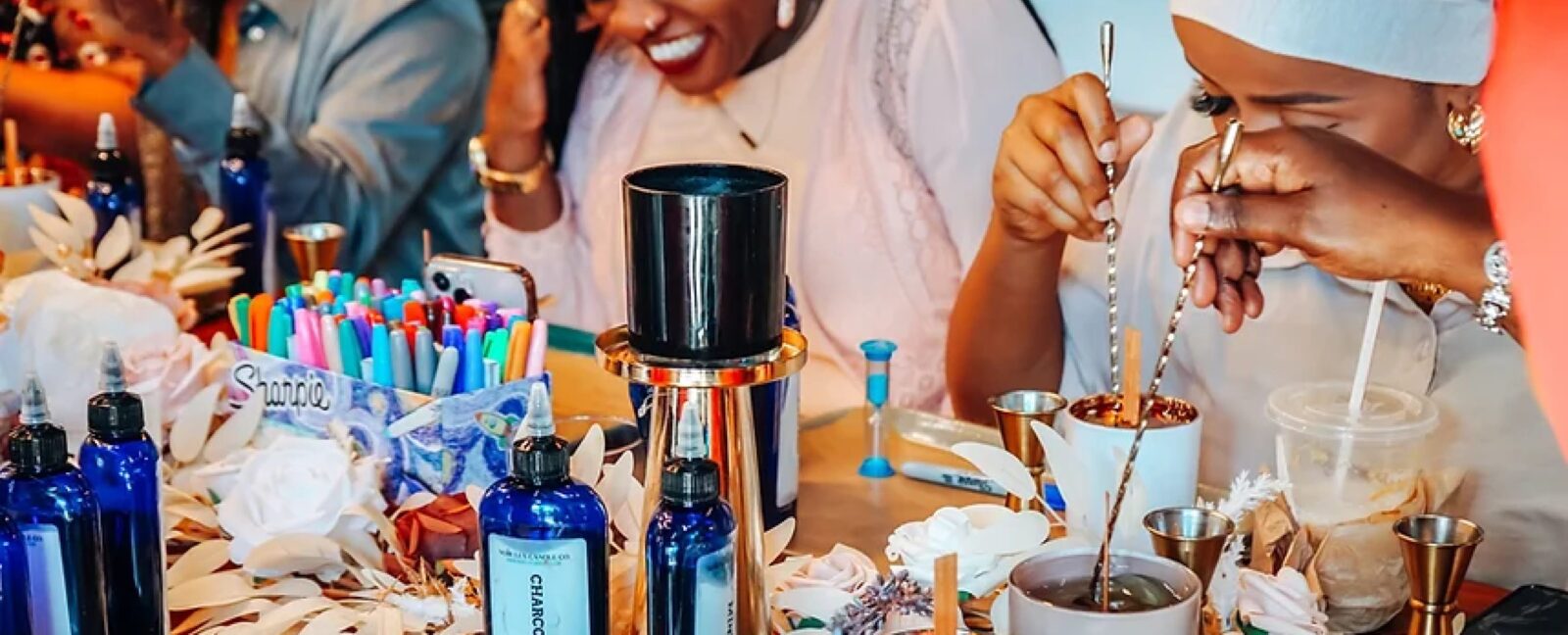 Smiling people making candles.