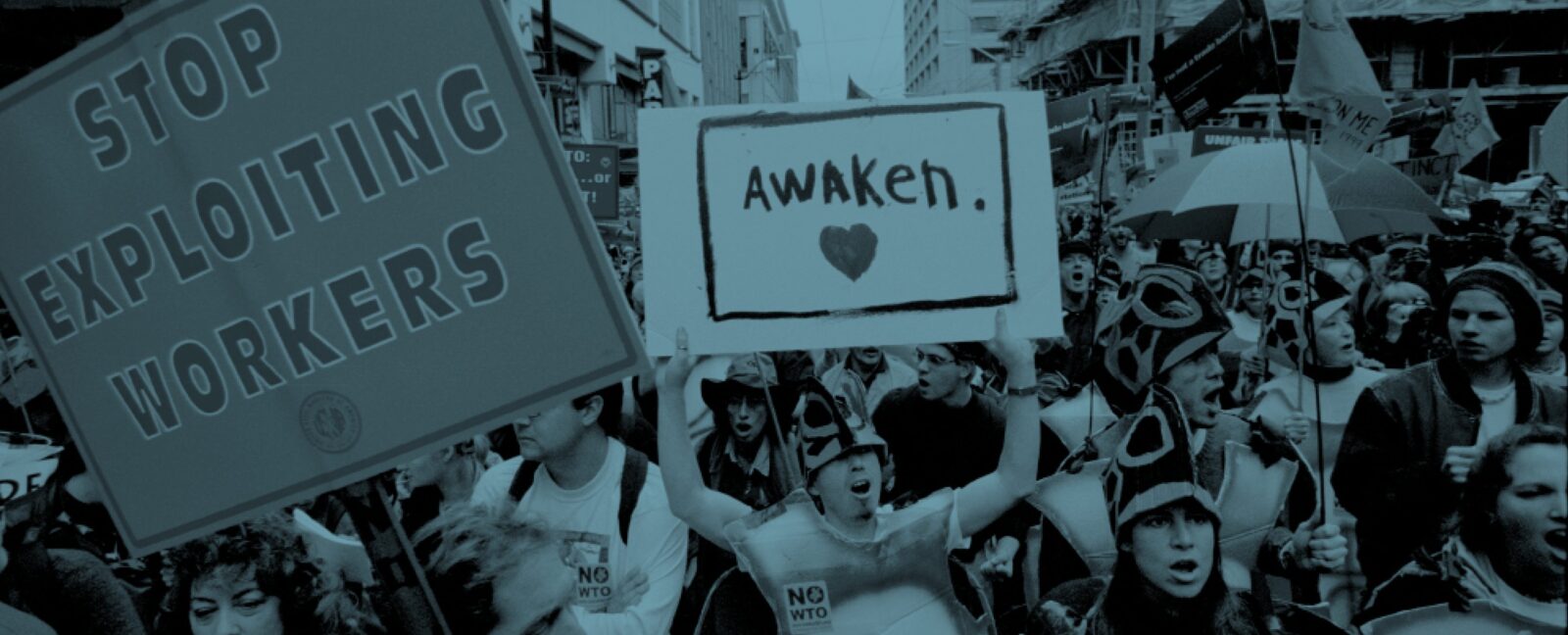 Activists marching in Seattle streets at the WTO protests of 1999. Visible signs read