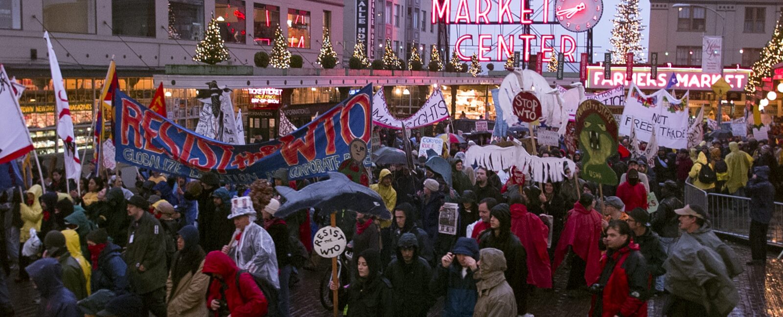 A crowd of protestors passing by the entrance to Pike Place Market.