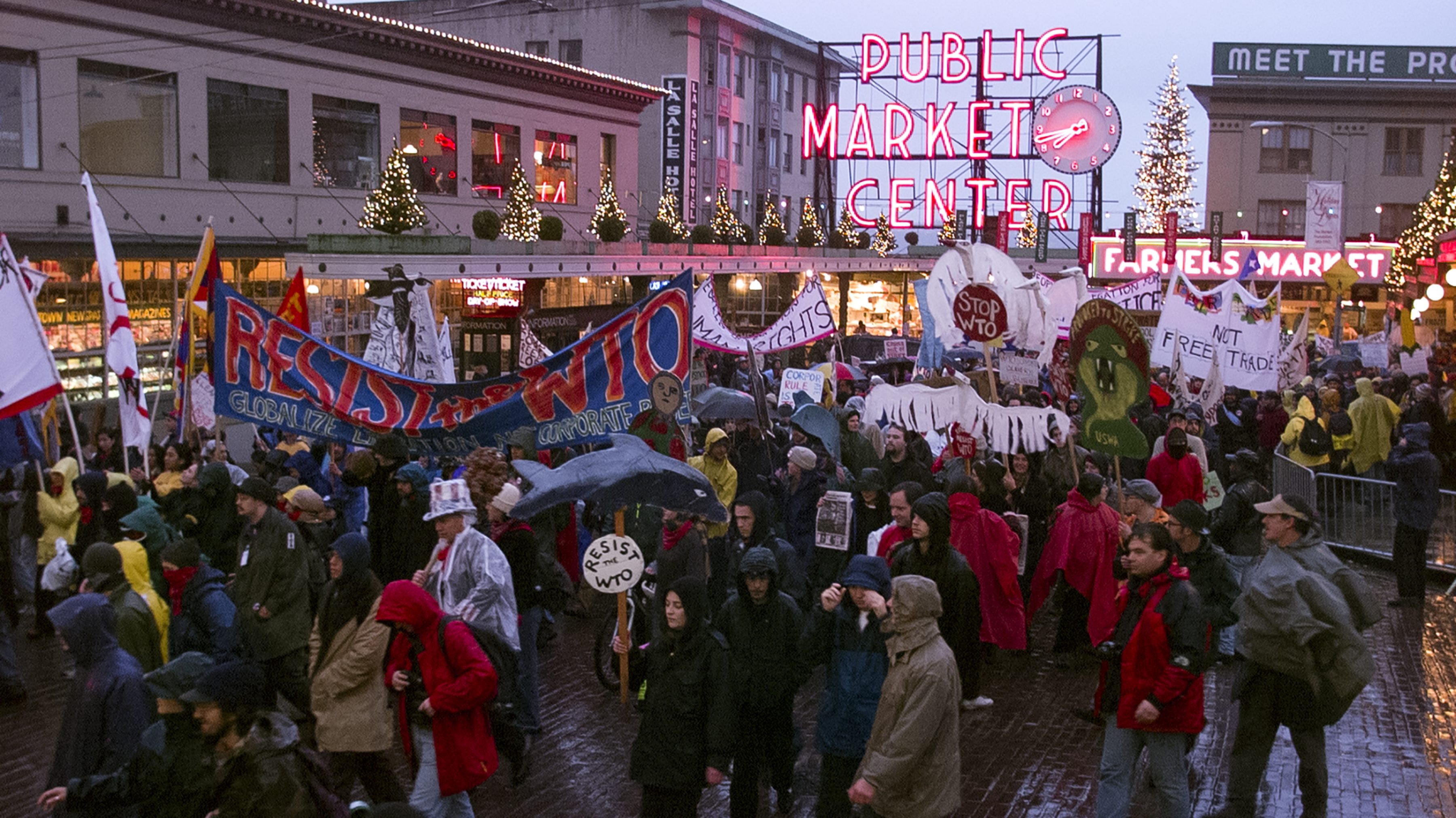 A crowd of protestors passing by the entrance to Pike Place Market.