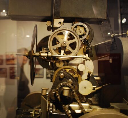 An antique film camera on display in a glass case at the Celluloid Seattle exhibit at MOHAI.