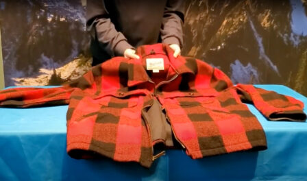 A red and black checkered, heavy flannel jacket displayed on a blue table.