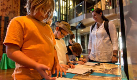 Children completing worksheets while attending a field trip at MOHAI.