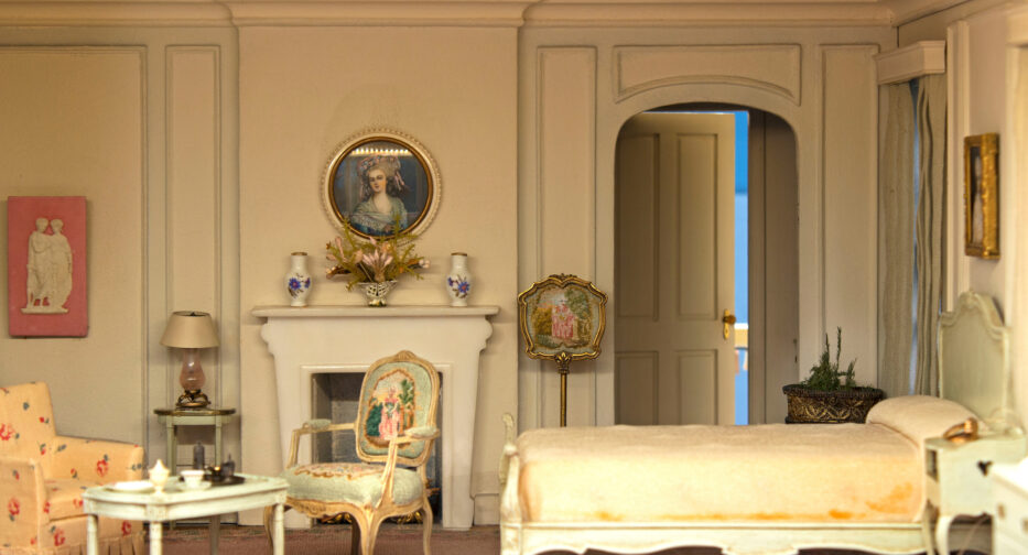 The interior of the Hammons House bedroom with bed, chairs, and fireplace.