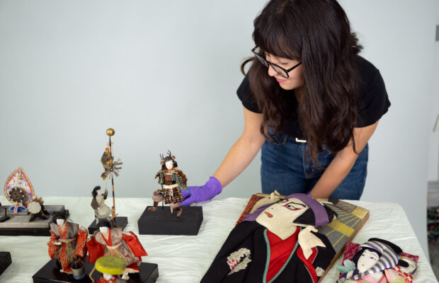 2024 Curator's Fellow Polly Yorioka with Japanese American Boys' and Girls' Day sets from MOHAI's collections.
