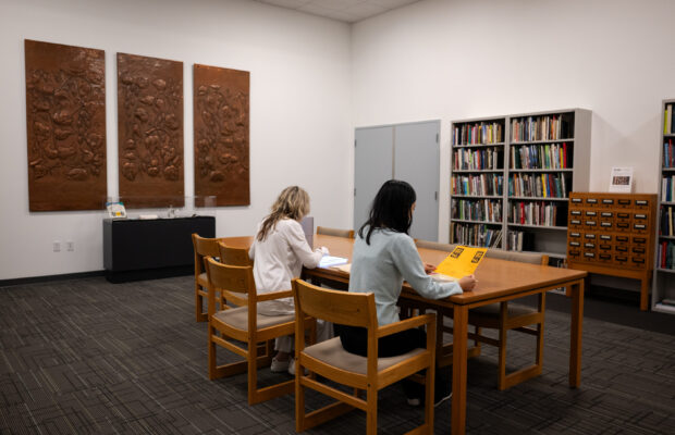 Two researchers sitting at a table in the Sophie Frye Bass Library at MOHAI.