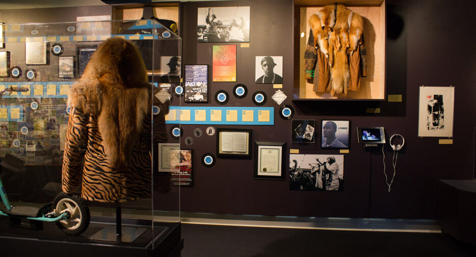 A section of The Legacy of Seattle Hip-Hop showing a timeline and jackets worn by Mackelmore and Raz Simone.