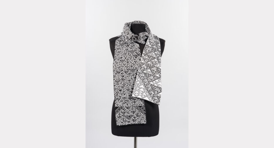 A black and white cellular automata knit scarf (KnitYak, 2018). Each stitch acts like a screen pixel: black and white stitches represent binary 0s and 1s.