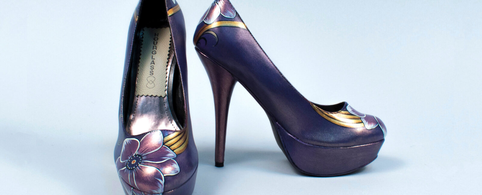 Purple high heel shoes with a flower painted on the toe.