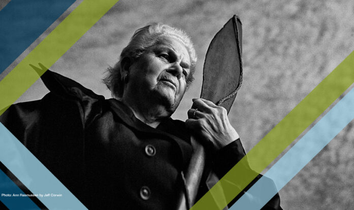 Ann Rasmussen gazing into the distance while holding a canoe paddle.