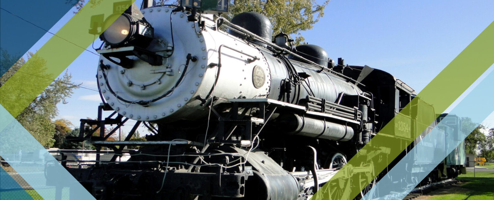 Train with 1354 on its side sits idle on track.