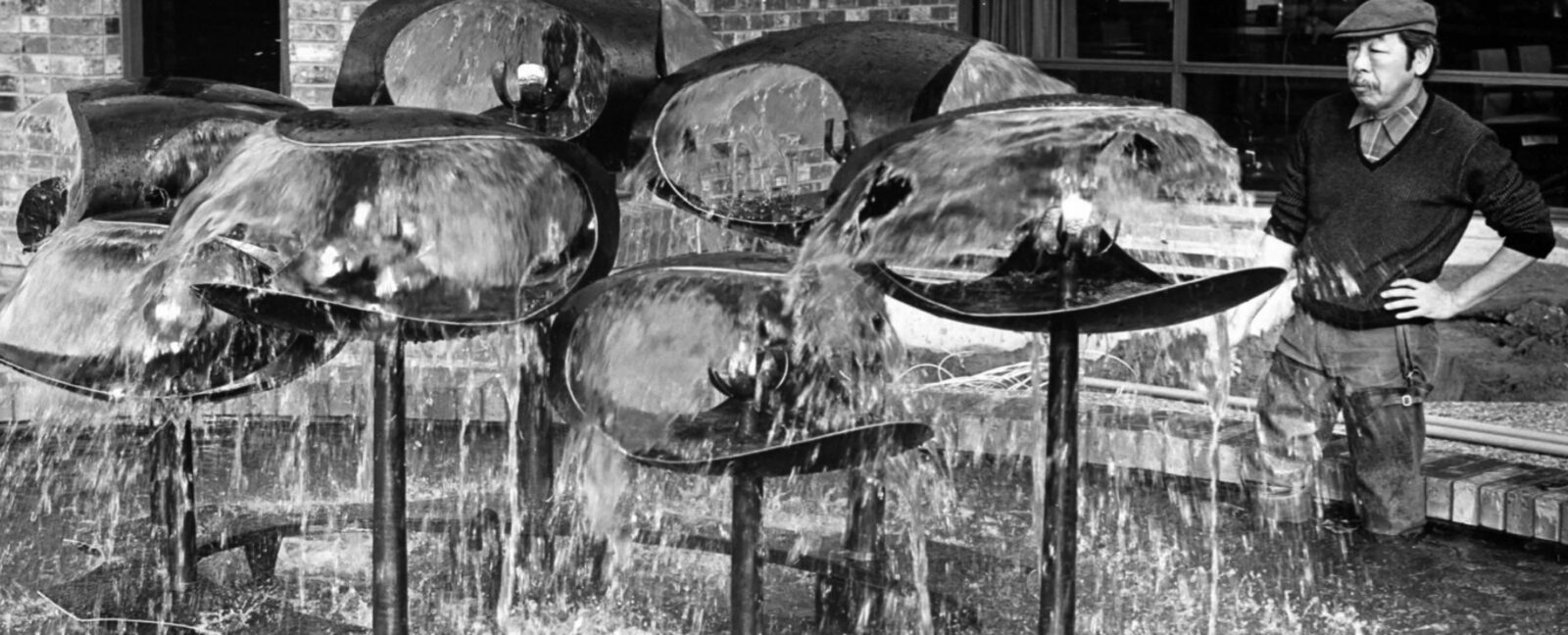 George Tsutakawa observes his water sculpture.