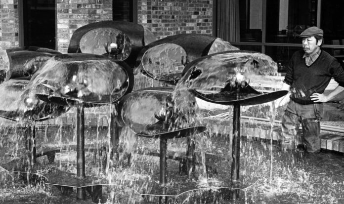 George Tsutakawa observes his water sculpture.