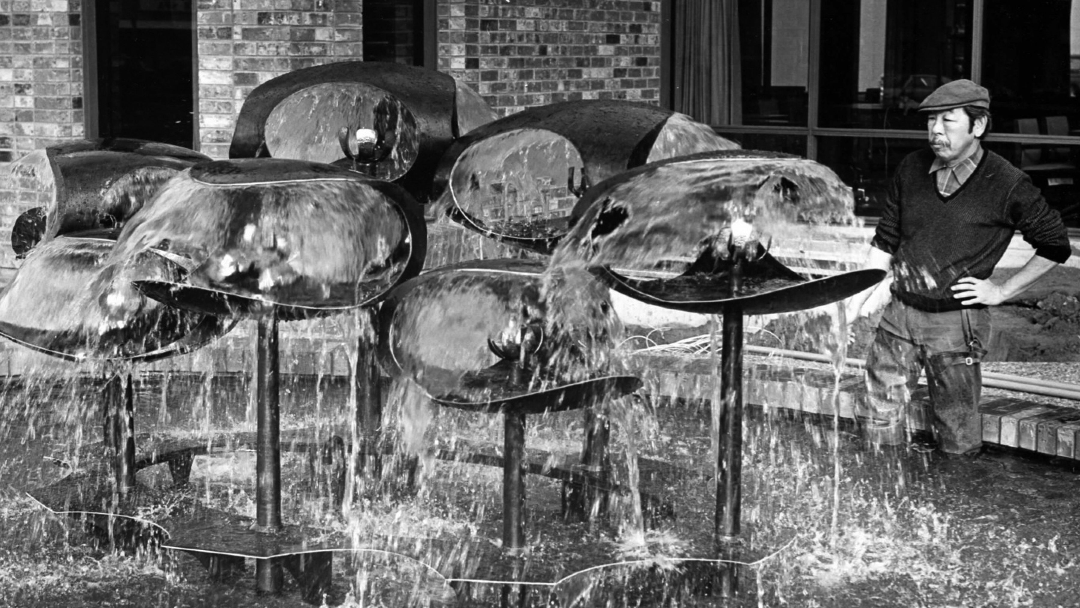 George Tsutakawa observes his water sculpture.