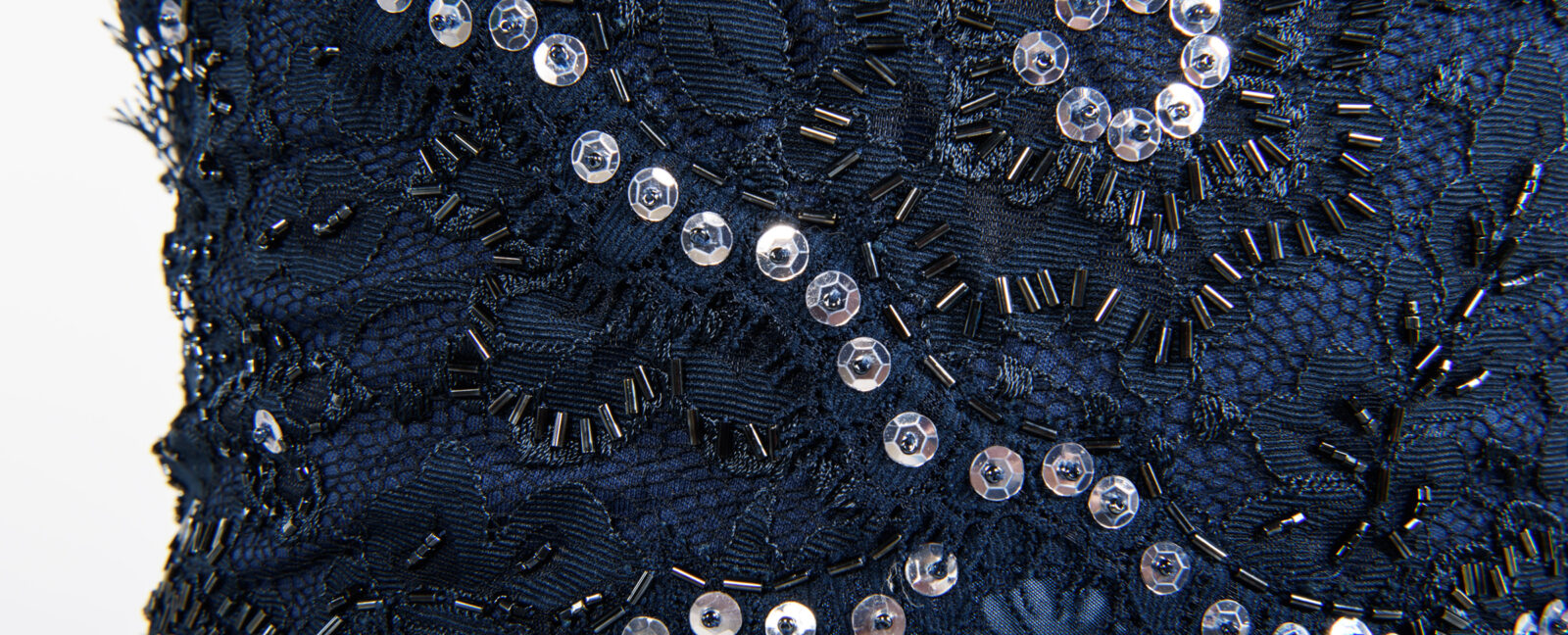 Close up of a blue gown covered in sequins and beads.