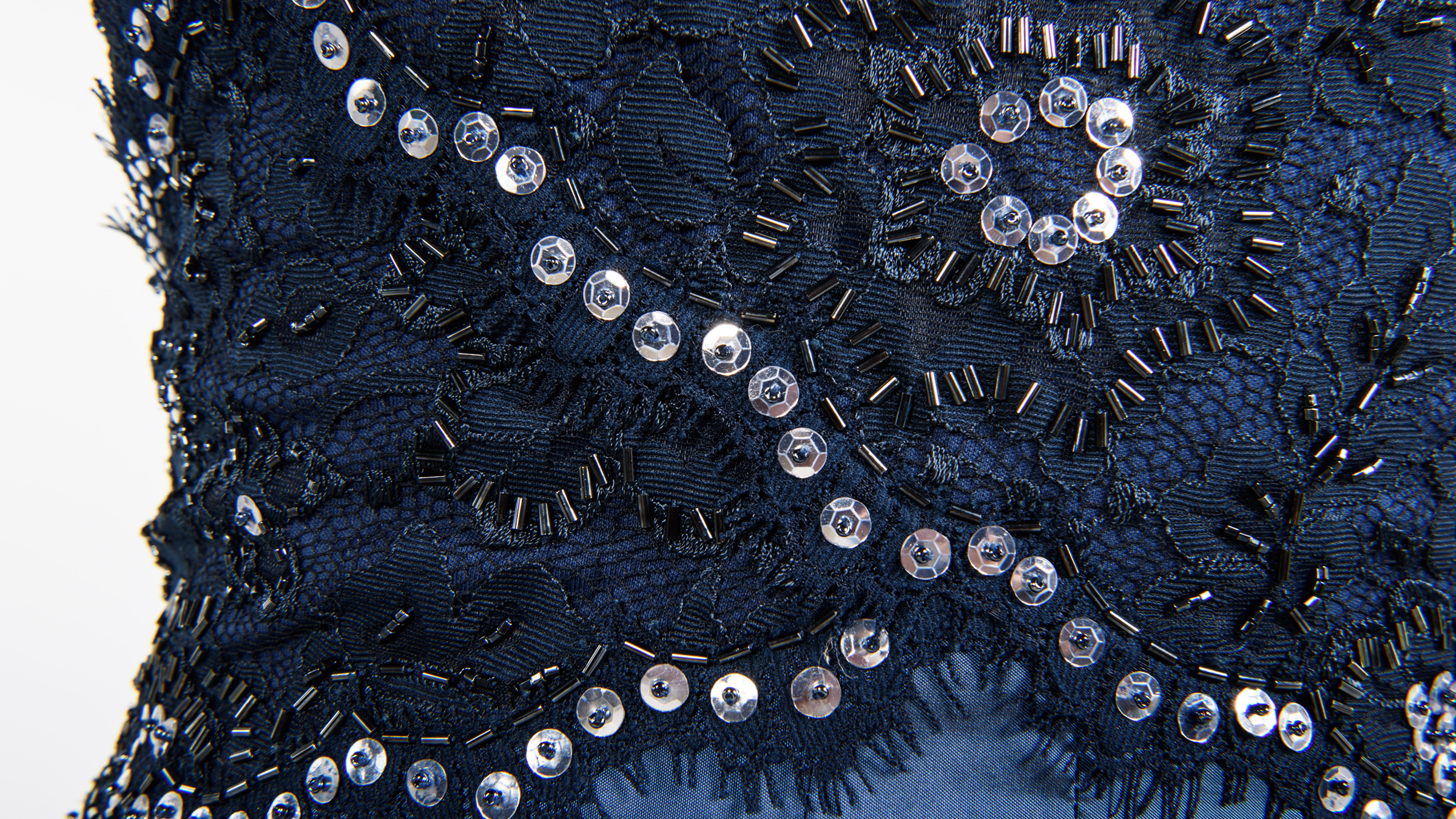 Close up of a blue gown covered in sequins and beads.