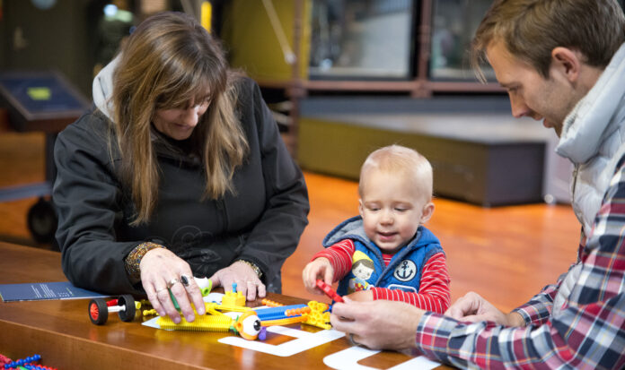 Child and parents playing with building toys.