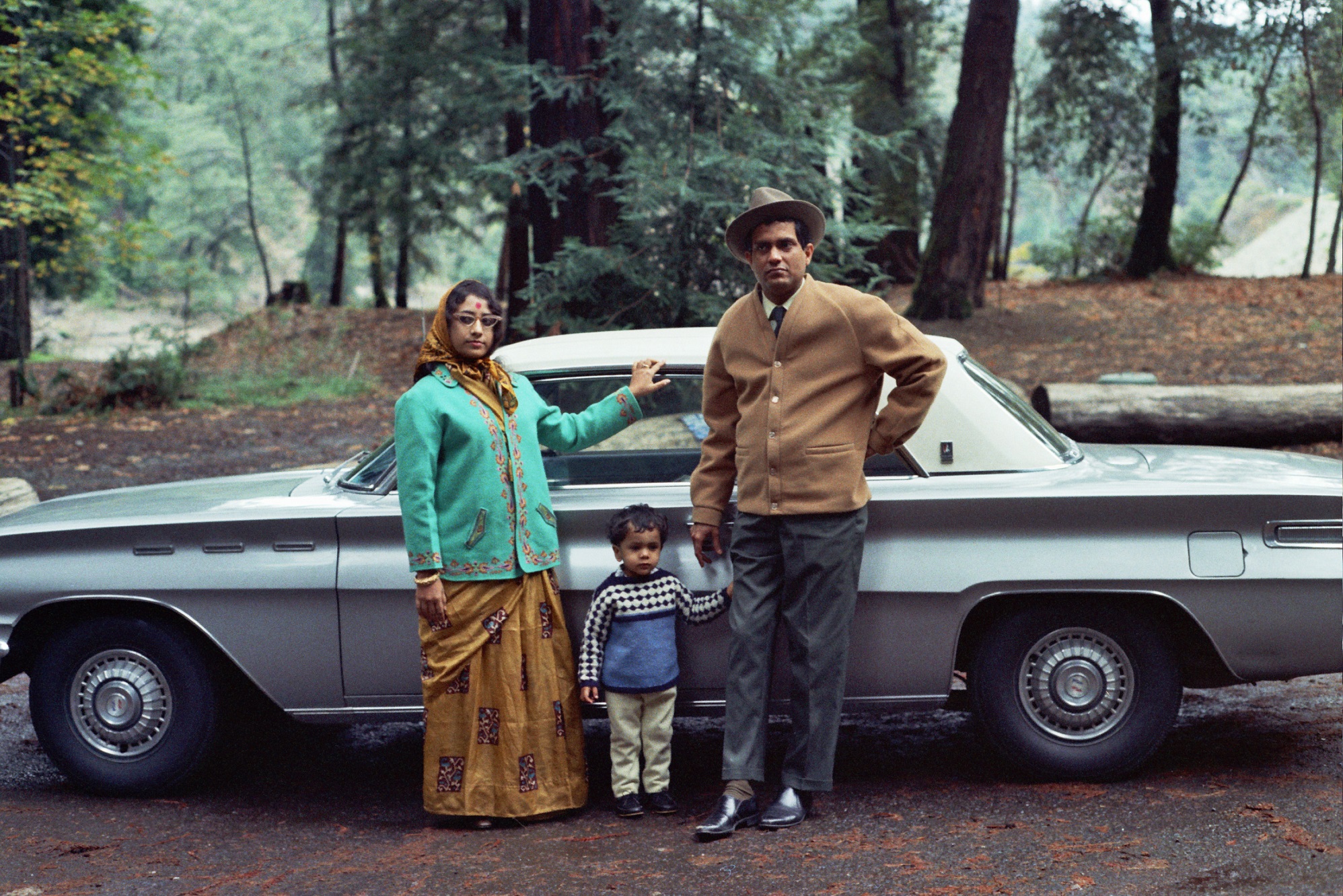 An Indian American family poses in front of their car in the 1960s.